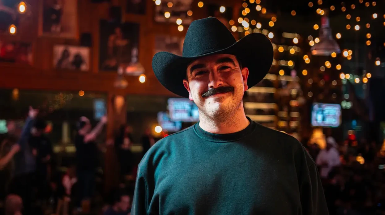 Un heureux monsieur avec une belle moustache et un chapeau de cowboy dans un restaurant